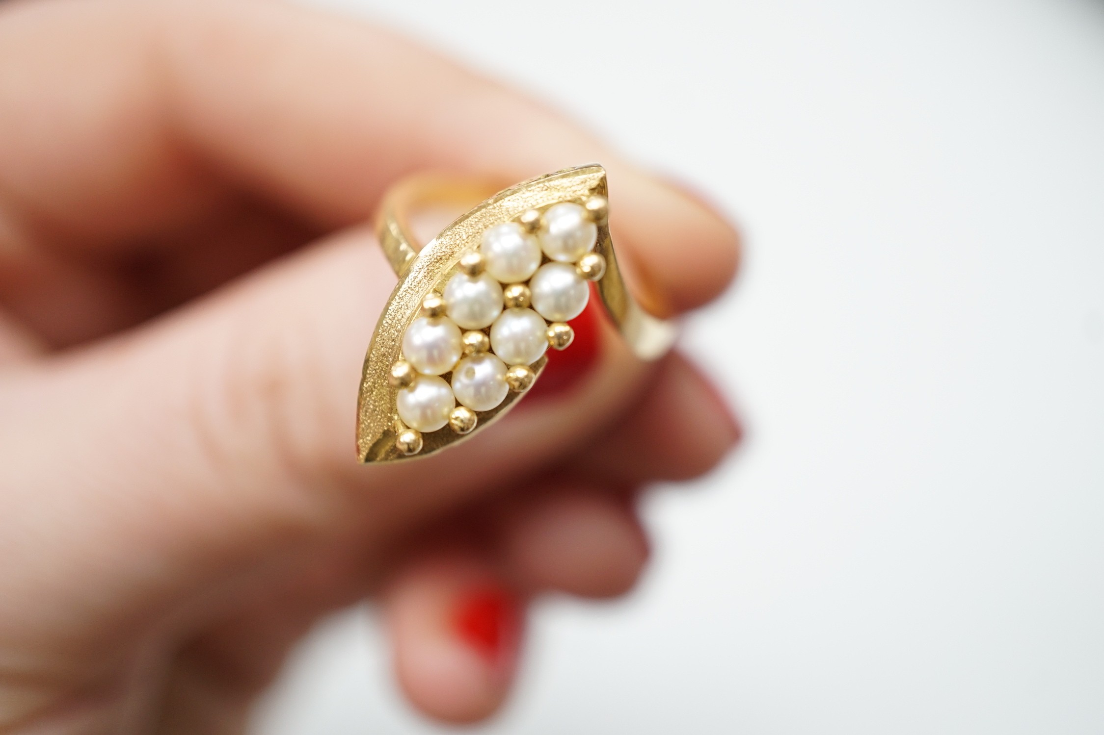 A modern continental yellow metal and seed pearl cluster set marquise shaped ring, size N